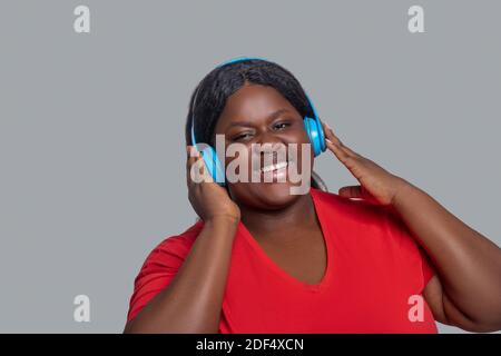 Young dark-skinned woman with headphones feeling enjoyed Stock Photo