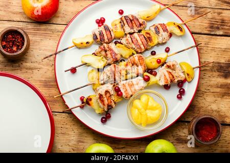 Delicious turkey shish kebab with apple on rural wooden table Stock Photo
