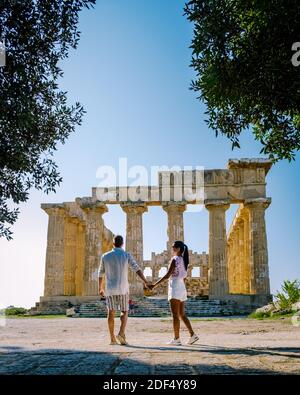 A couple visit Greek temples at Selinunte during vacation, View on sea and ruins of greek columns in Selinunte Archaeological Park Sicily Italy Stock Photo