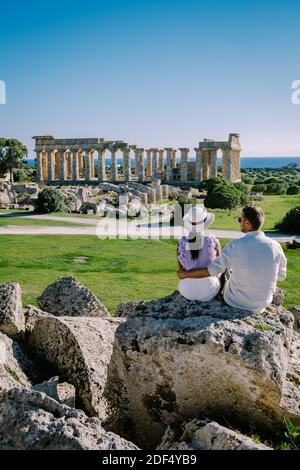 A couple visit Greek temples at Selinunte during vacation, View on sea and ruins of greek columns in Selinunte Archaeological Park Sicily Italy Stock Photo