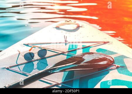 Fashion sunglasses on a paddleboard surf. Relax and travel. Hot summer day. Water sports. Vacation at sea. Stock Photo