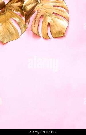 Luxury natural background with golden tropical leaves. Gold monstera leaf on pastel pink background. Clean minimal flat lay design. Trendy chic lifest Stock Photo