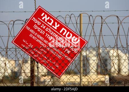 Israeli red signboard warning about approaching to closed military area. Written in Hebrew, English and arab languages. Stock Photo