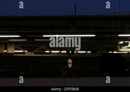 A salaryman or Japanese male office worker waiting at Shimbashi station, Tokyo Japan, Stock Photo