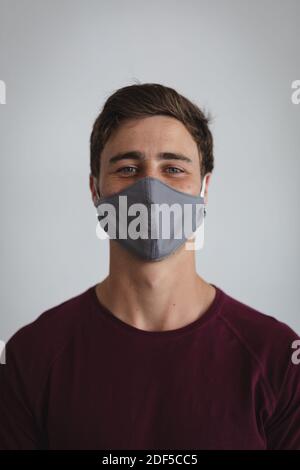 Portrait of caucasian man wearing face mask against grey background Stock Photo