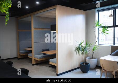 Empty cafeteria in creative office with booths, table, window and plants Stock Photo
