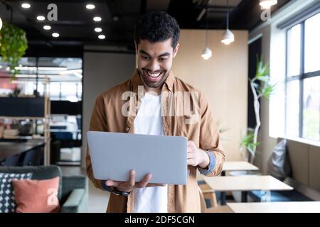 Smiling mixed race businessman using laptop during video call in office Stock Photo