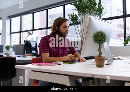 Caucasian man working in creative office, using graphic tablet Stock Photo