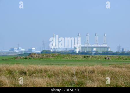The 4 rectangular towers of Connah's Quay Power Station and the Flintshire Bridge dominate the skyline over the Dee Estuary from the Wales Coast Path. Stock Photo