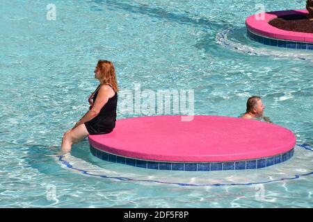 Las Vegas NV USA 9-30-18 A bather is sitting on one of the small islands of the pool complex of the Flamingo Hotel better known as The Beach Club Pool Stock Photo