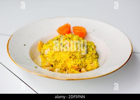Asty rice pilaf with vegetables isolated on white table. Stock Photo