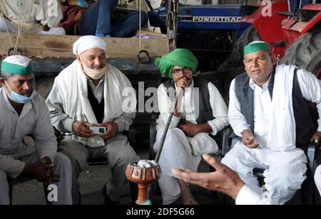 New Delhi, India. 03rd Dec, 2020. Farmers from North India's state Uttar Pradesh sit smoking a chilum blocking highway as they are not allowed to enter New Delhi to protest against the Farm Act. Protesting farmers say the new laws were passed without consultation with the people who may be affected by them. (Photo by Sondeep Shankar/Pacific Press) Credit: Pacific Press Media Production Corp./Alamy Live News Stock Photo