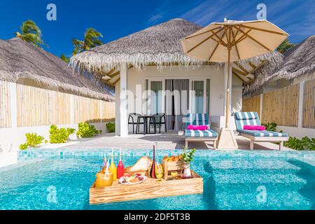 Breakfast in swimming pool, floating breakfast in luxurious tropical resort. Table relaxing on calm pool water, healthy breakfast fruit plate, luxury Stock Photo
