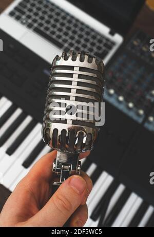 Man holding retro microphone in music studio. Ready to sing! Stock Photo