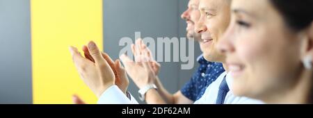 Business people are applauding and looking into distance. Stock Photo
