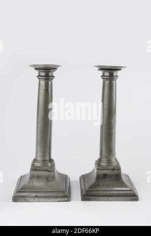 Anonymous, c. 1800, Two pewter candlesticks in Louis XVI style. The candlesticks have a square pyramidal concave high arched base with a round profiled base of a column on top, separated by a ridge from a vertical, slightly tapering column shaft with a profiled projecting top edge. A loose saucer-shaped bobche or grease trap rests on the top edge, which fits into the hollow column shaft, 1948 Stock Photo