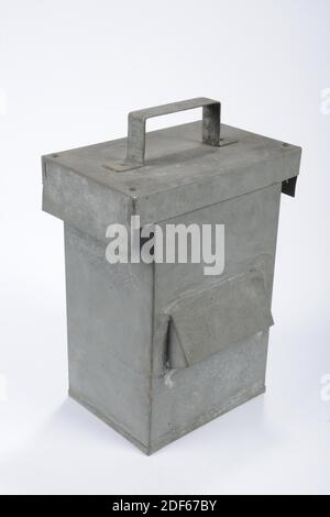 black-out lamp, Anonymous, 1940-1945, glass, enamel paint, iron, painted, General: 35.5 x 32.5 x 33.6cm (355 x 325 x 336mm), Cover A: 9 x 24cm (90 x 240mm), Drum W: 35 x 32.5 x 33.6cm (350 x 325 x 336mm), Four-hole cylindrical container with funnel-shaped protuberances. Behind each hole is a piece of blue glass clamped with iron wire. A ring on three legs is attached to the bottom of the cylinder where you can put something in or on it. Two hooks are attached to the top of the rim to secure the corresponding lid. The lid has two slots and two iron strips with which the lid is held by the hooks Stock Photo