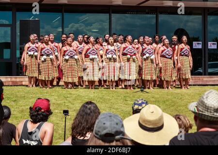 A group of Maori kapa haka (traditional dance) performers singing in front of a crowd Stock Photo