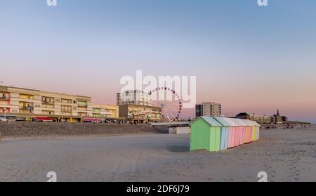 Pastel colored beach cabins and giant wheel along the Opal Coast in the North of France. Stock Photo