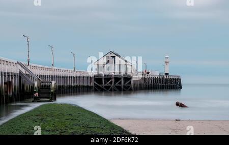Old pier and breakwater on the Belgian coast in Blankenberge. Long exposure image.