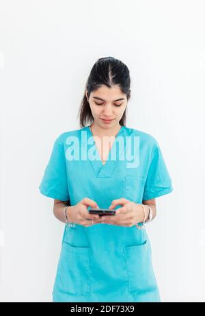 Nurse using smartphone standing in the clinic with withe background Stock Photo