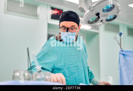 Surgeon Inserting Tube Into Patient During Surgery Stock Photo