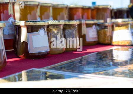 Selling homemade flower honey and honey products on the stand in the city park. Stock Photo