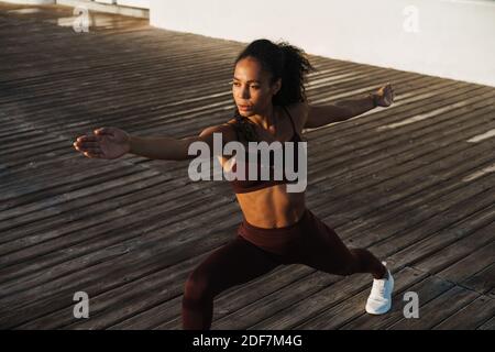 Young beautiful concentrated african american woman doing workout outdoors Stock Photo