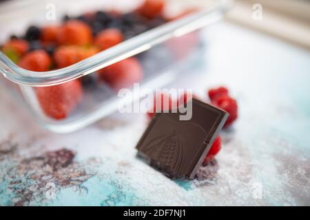 Bitten chocolate bar and raspberries on a colorful placemat Stock Photo