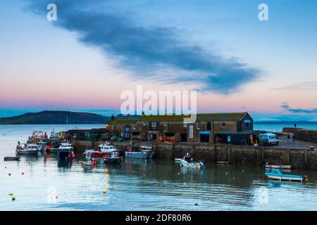 Lyme Regis, Dorset, UK.  3rd December 2020.  UK Weather.  A pink glow in the sky above the Cobb harbour at Lyme Regis in Dorset shortly after sunset.  Picture Credit: Graham Hunt/Alamy Live News Stock Photo