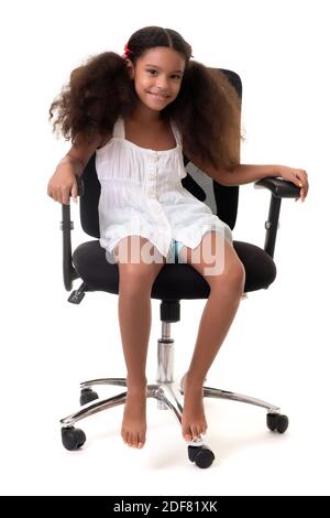 Cute multiracial small girl sitting on an office chair - Isolated on a white background Stock Photo