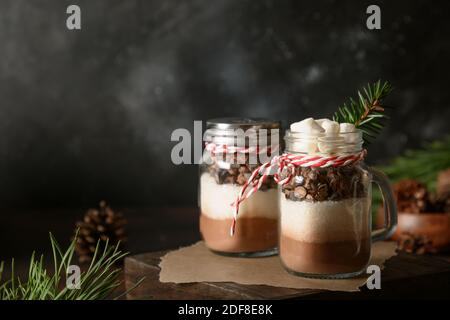 Two homemade Christmas gift in mason jar for chocolate drink on dark. Close up. Stock Photo