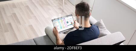Man Using Spreadsheet Data On Tablet Computer Stock Photo