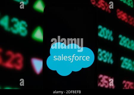 In this photo illustration a SalesForce logo is displayed on a smartphone with stock market graphics on the background. Stock Photo