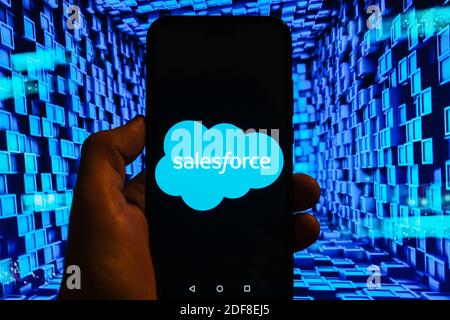 In this photo illustration a SalesForce logo is displayed on a smartphone with stock market graphics on the background. Stock Photo