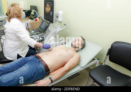 a female doctor examines a patient on an ultrasound machine Stock Photo