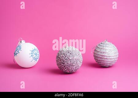 Christmas New Year composition. Gifts, silver and white ball decorations on pink background. Winter holidays concept. Angle view Stock Photo