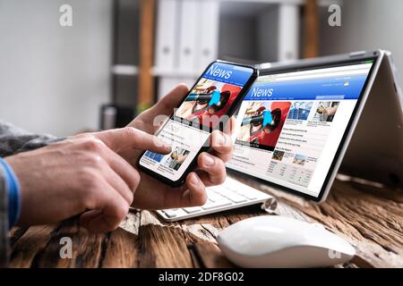 Reading News Website Online On Convertible Laptop Stock Photo