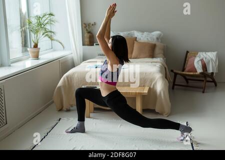 Girl is engaged in gymnastics, yoga, in her home. Stock Photo