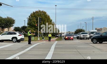 Allen, TX USA - November 27, 2020: Roadside view of police officers guiding the cars of Black Friday traffic Stock Photo