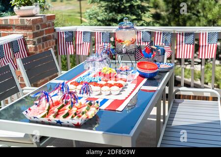 Table with food and drinks set for celebrating July 4th on the back patio. Stock Photo