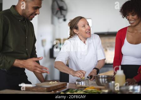 Female chef and divserse group in kitchen Stock Photo