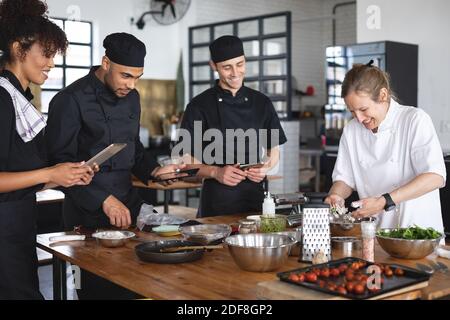 Female chef and divserse group in kitchen Stock Photo
