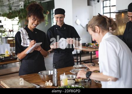 Female chef and divserse group in kitchen Stock Photo
