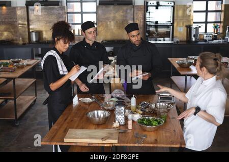 Female chef and divserse group in kitchen Stock Photo