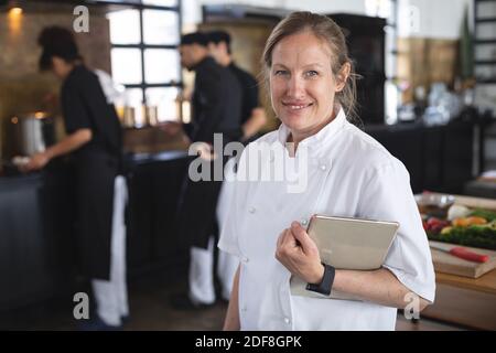 Female chef and divserse group in kitchen Stock Photo