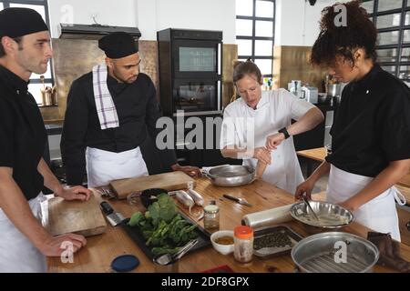 Female chef and divserse group in kitchen Stock Photo