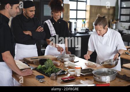 Female chef and divserse group in kitchen Stock Photo