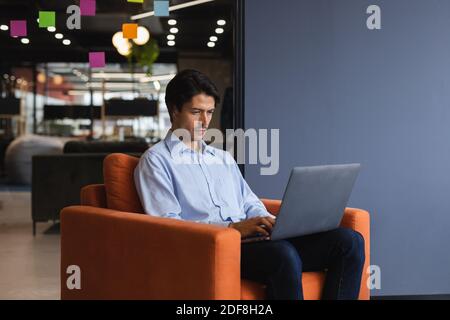 Caucasian businessman using laptop computer in creative office Stock Photo