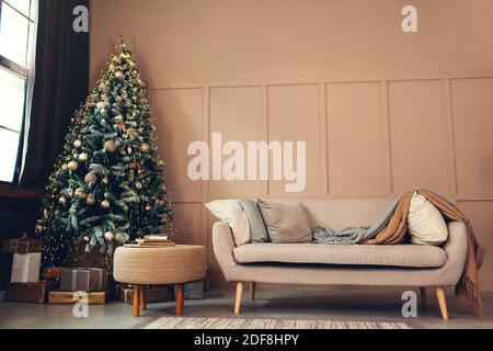 Christmas studio interior with decorated Christmas tree, gift boxes and cozy couch. New year and Christmas empty photo studio Stock Photo